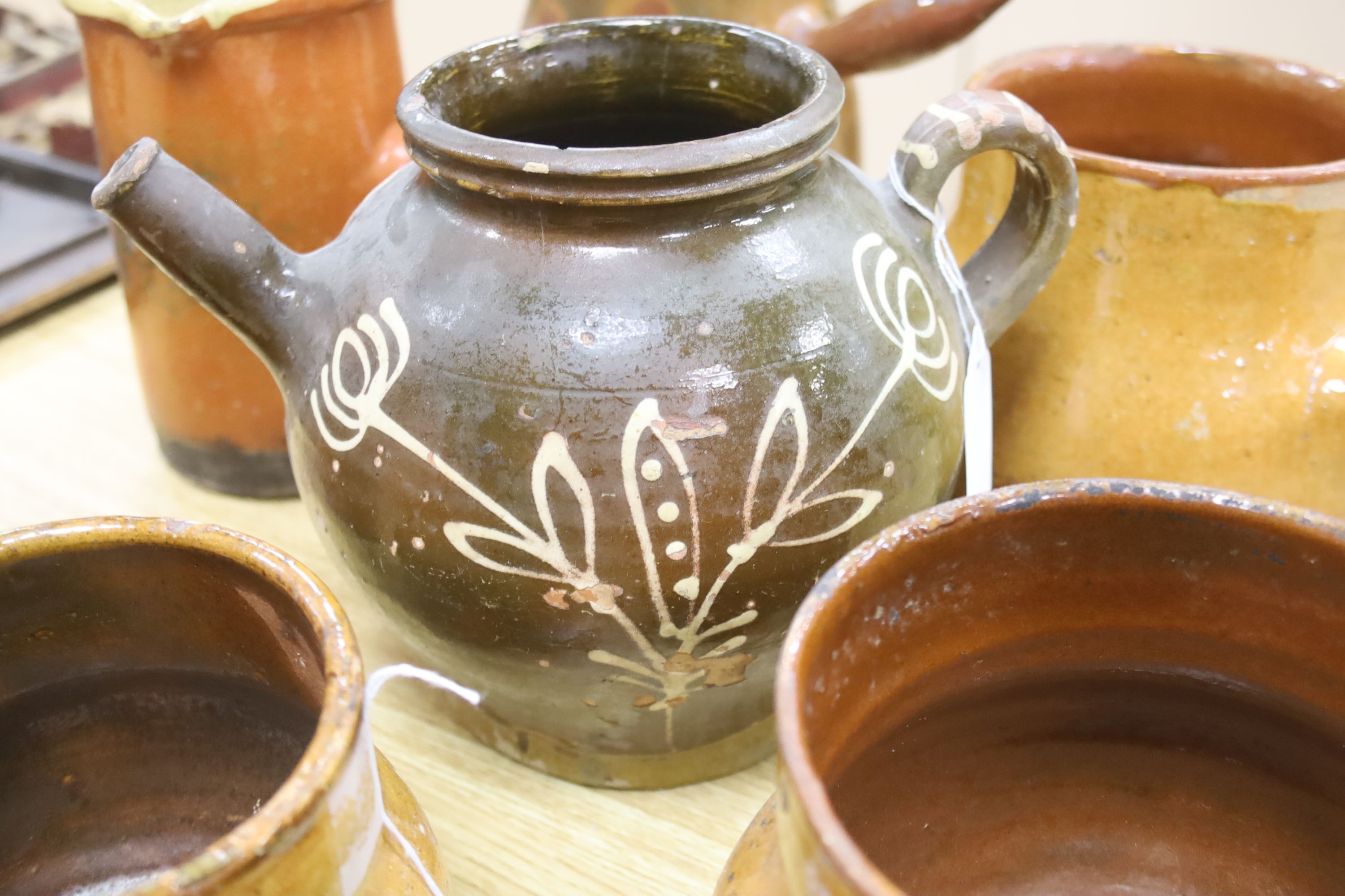 Six vintage Continental, probably French, glazed stoneware cooking pots and a slip-decorated stoneware confit pot